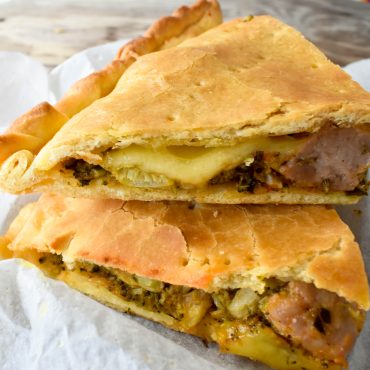 Schiacciata pizza filled with broccoli and pork sausage