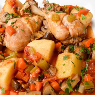 Chicken drumsticks with mushrooms, potatoes and tomatoes